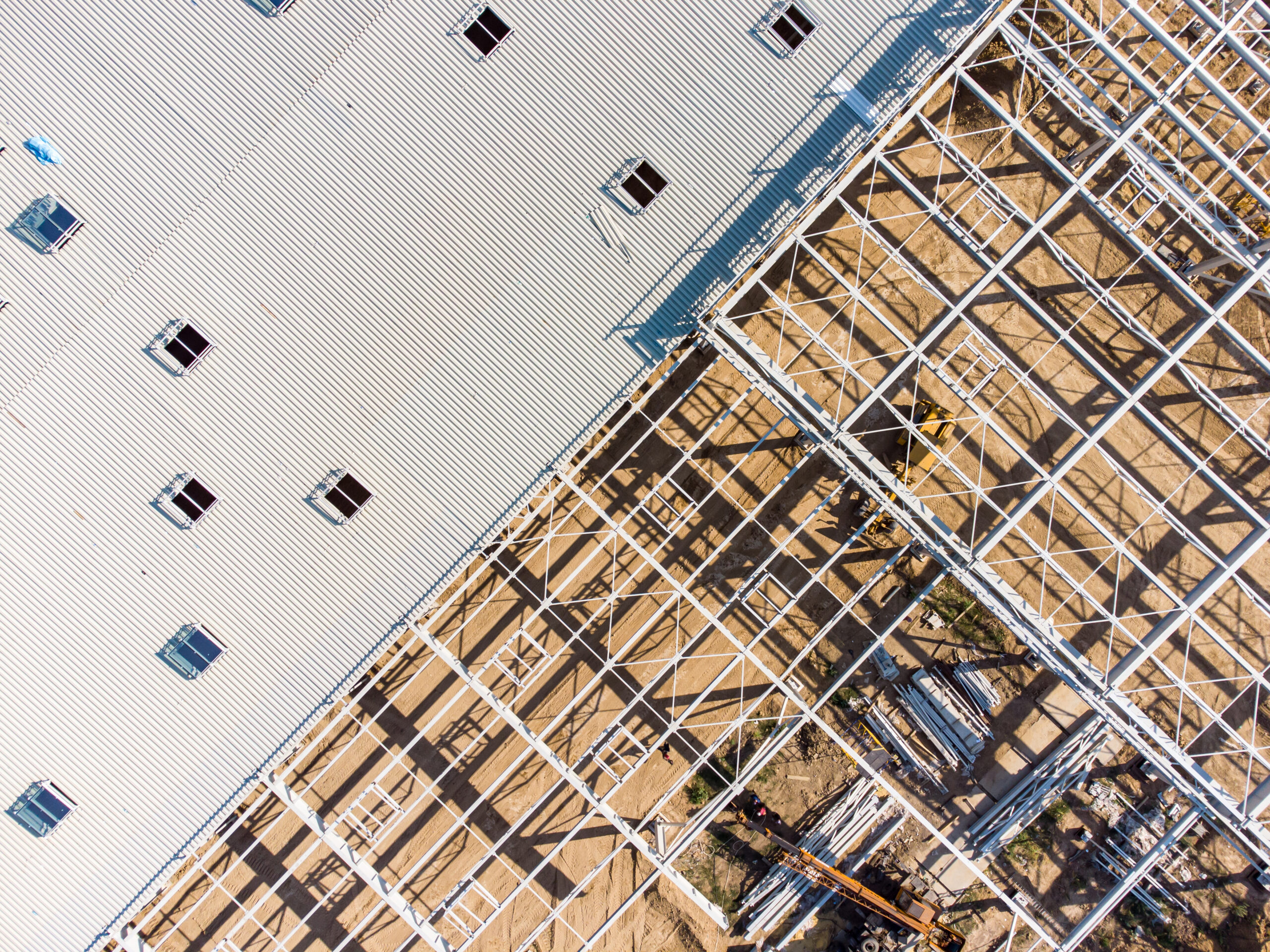 Aerial view of warehouse construction from steel metal structure. Frame of modern hangar or factory construction site